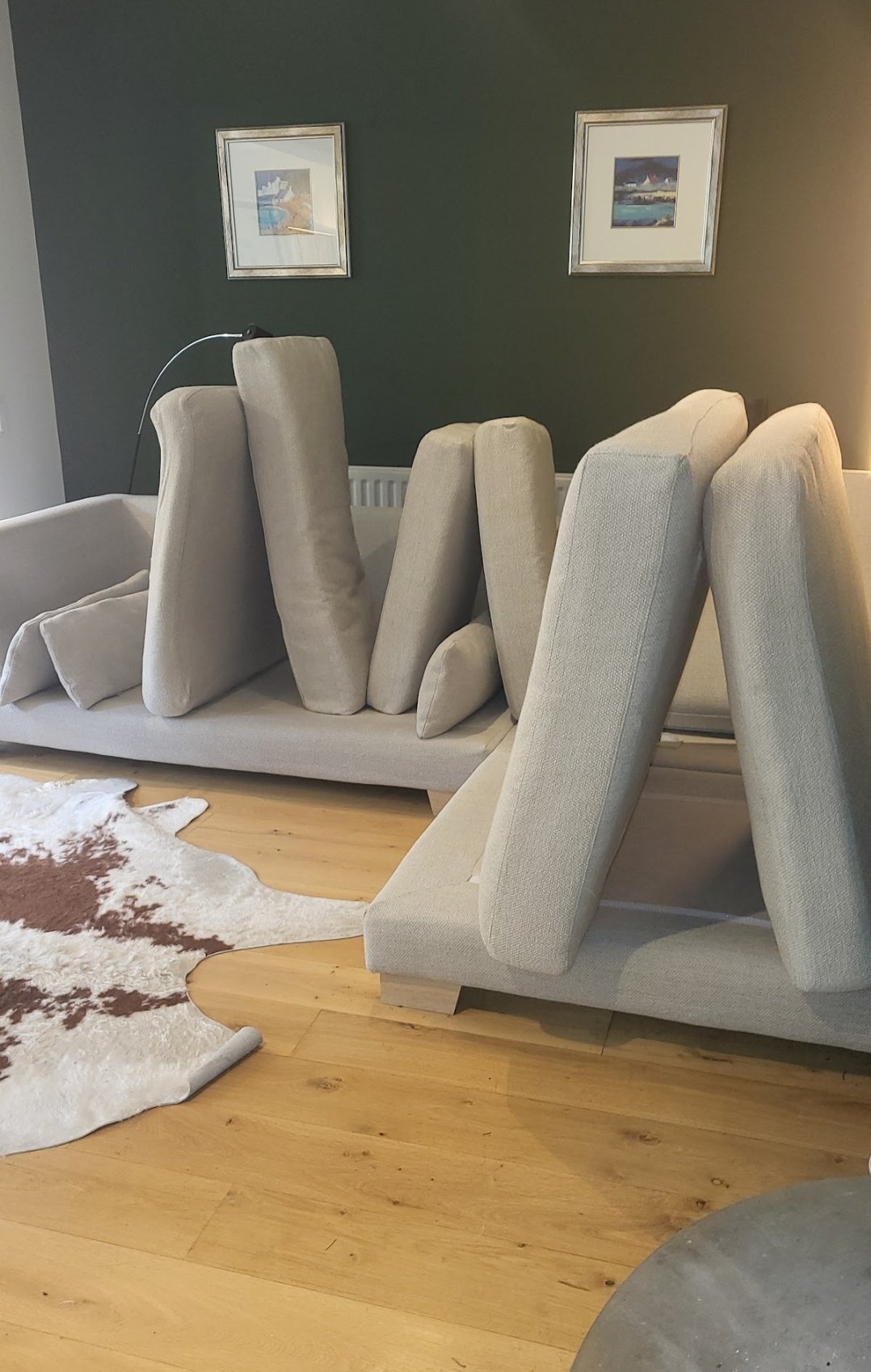 Light grey sofa cushions propped up to dry after professional upholstery cleaning