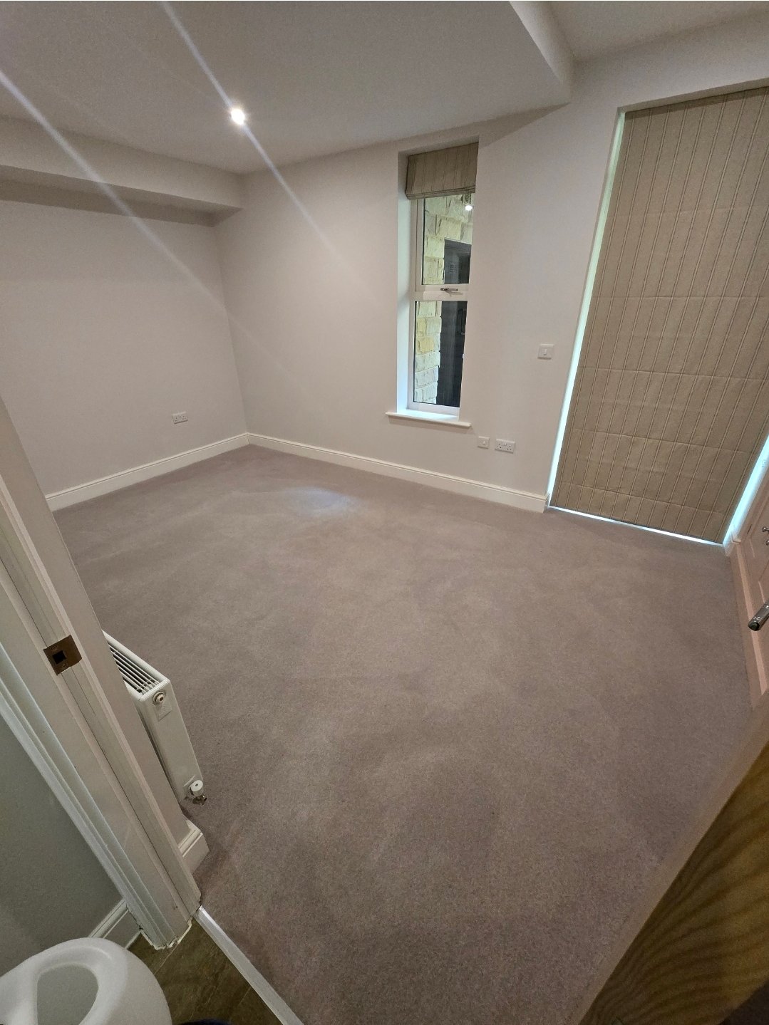 Cleaned grey carpet in a Harrogate room with stone window view