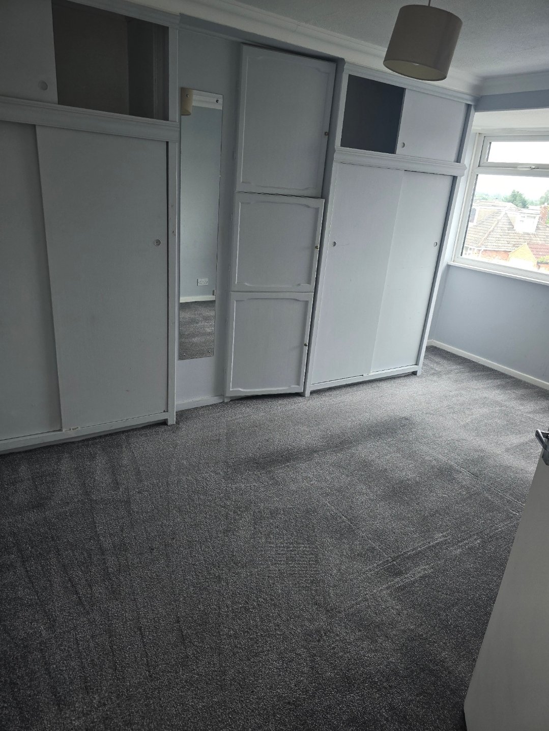 Bedroom with grey carpet and white fitted wardrobes after cleaning in Harrogate