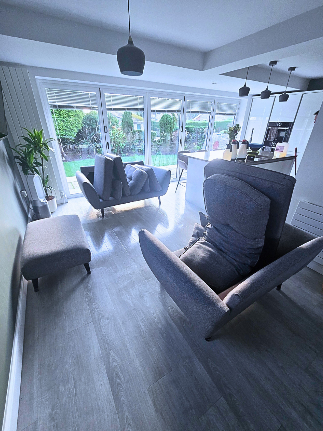 Professional upholstery cleaning on grey fabric sofa in Leeds home with equipment in background